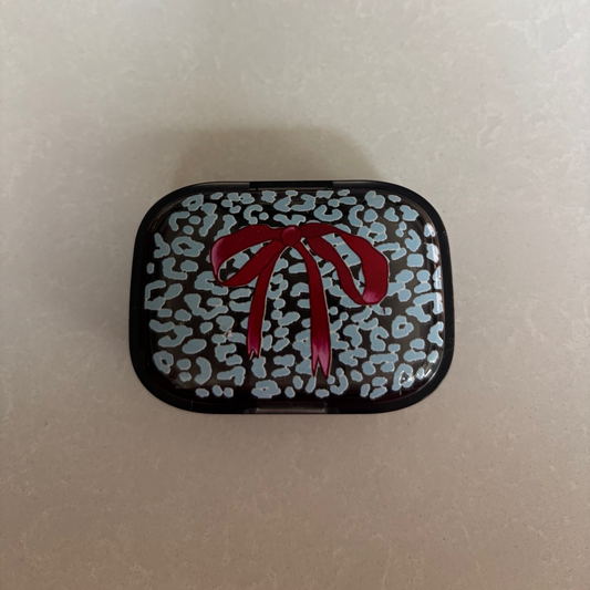 Ice Blue Leopard print background & large Burgundy Bow on a Black Pill Pot